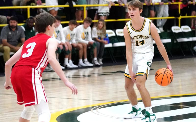 Kaden Keiser (13) holds the ball at the top of the key looking for a teammate to pass to. CONTRIBUTED