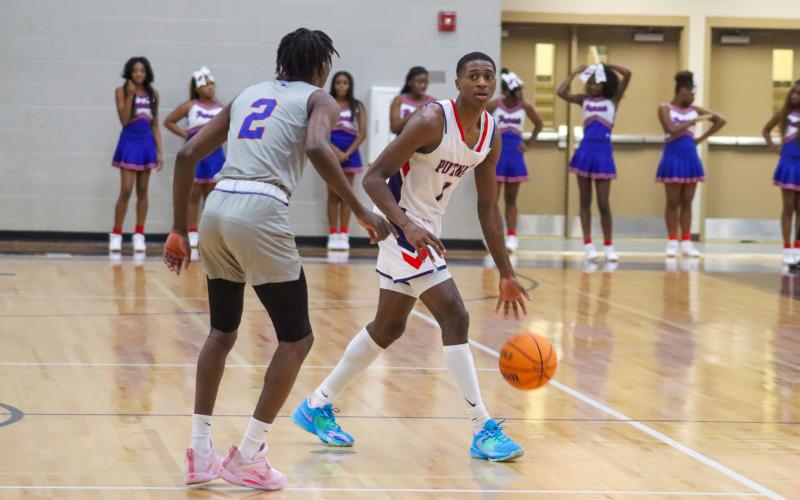 Eren Banks runs the point guard position, dribbling the ball at the top of the court trying to shake Westside's Demarco Middleton (2).