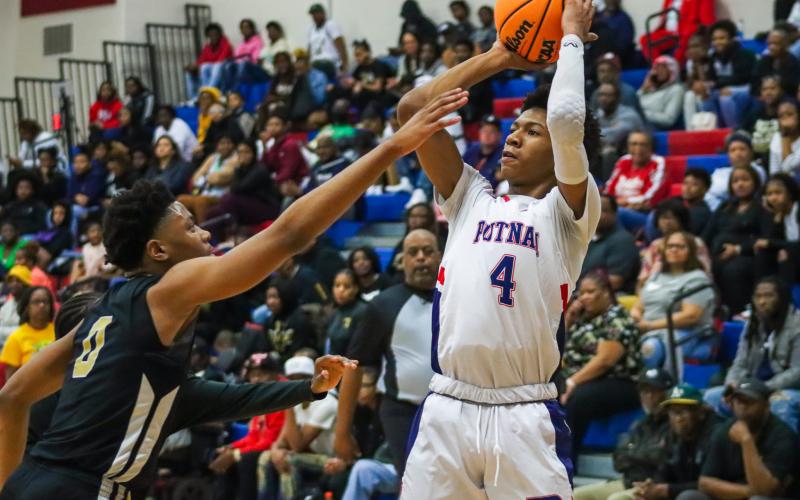 Putnam County point guard Keyni Crawford (4) pulls up for a 3-pointer in the second quarter of the War Eagles' 52-41 win over Butler in the Region 4-AA semifinals on Thursday, Feb. 16. He scored a game-high 19 points as Putnam County advances to the final against Westside (Augusta) on Friday. BRENDAN KOERNER/Staff