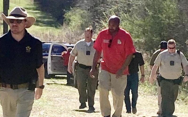 JCSO Lt. Kenny Gleaton (l-r) PCSO deputy Jim Barbee, Putnam Deputy Coroner Andre Williams, PCSO Deputy Paul Bernichon and other Jones and Putnam authorities walk back to their vehicles after recovering a body on Cedar Creek Sunday afternoon. LYNN HOBBS/Staff