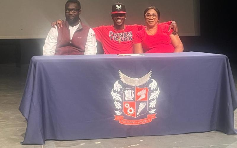 Jermaine Nelson poses between his father Brenton Nelson and mother Latoya Smalling during his signing ceremony for Thomas University. CONTRIBUTED