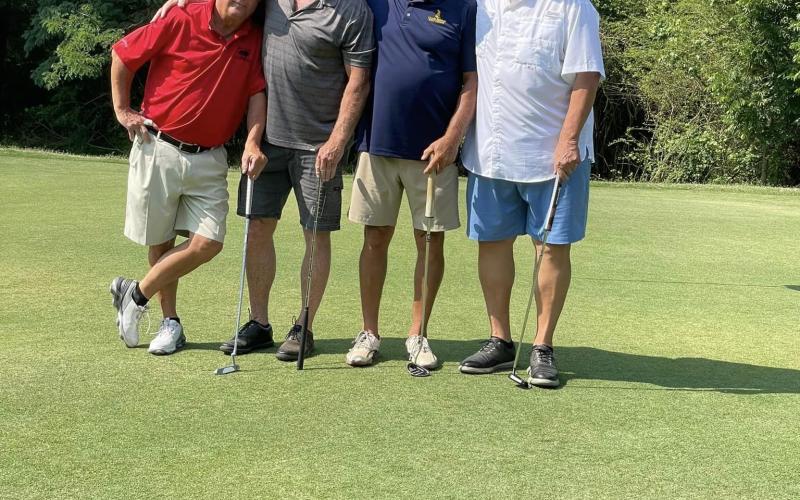 Four golfers pose for a photo on a green at the War Eagle Scramble. CONTRIBUTED