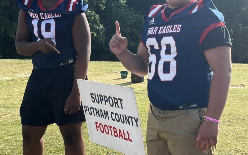 Two Putnam County football players greet guests as they walk in to the course. CONTRIBUTED