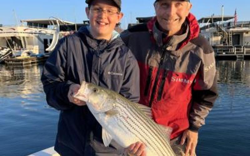 Beau and Henry Cowen with a 12-pound striper that hit topwater this past Monday morning on Lake Lanier. CONTRIBUTED