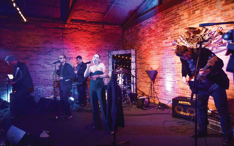 A performer at one of two “living tables” provided wine and ArtiGras beads to guests at The Livery before the party moved next door to Barrel 118. IAN TOCHER/Staff