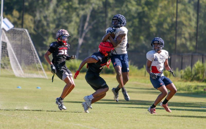 Putnam County senior wide receiver Jayson Smith (14) makes a catch in mid-air over a Winder-Barrow defender. LANCE McCURLEY/Staff