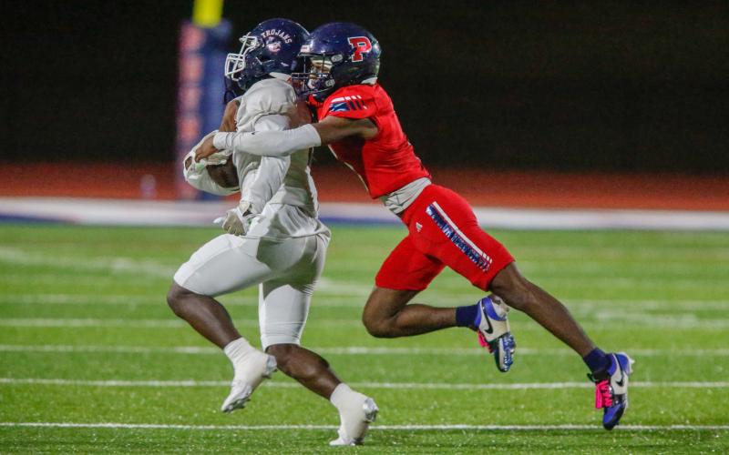 Putnam County defensive back RJ Hines (right) tries to bring down a Trojan running back Jayen Hillman (left). LANCE MCCURLEY/Staff