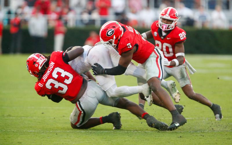 Georgia defensive lineman Quintavius Johnson (33) and linebacker CJ Allen (3) bring down an Ole Miss ball carrier. LANCE MCCURLEY/Staff