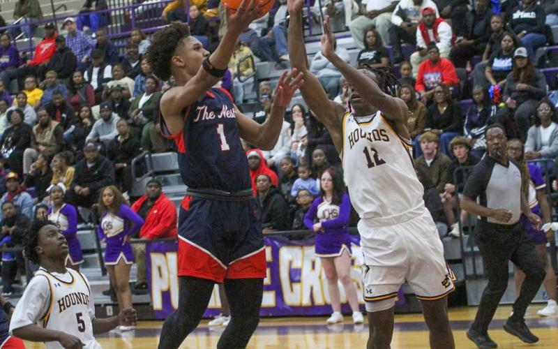 Putnam County junior Jeremy Banks (1) gets set to float a shot over Jones County's Jaiden Bond (12) in a loss to the Greyhounds on Jan. 3. BRAD HARRISON/Staff