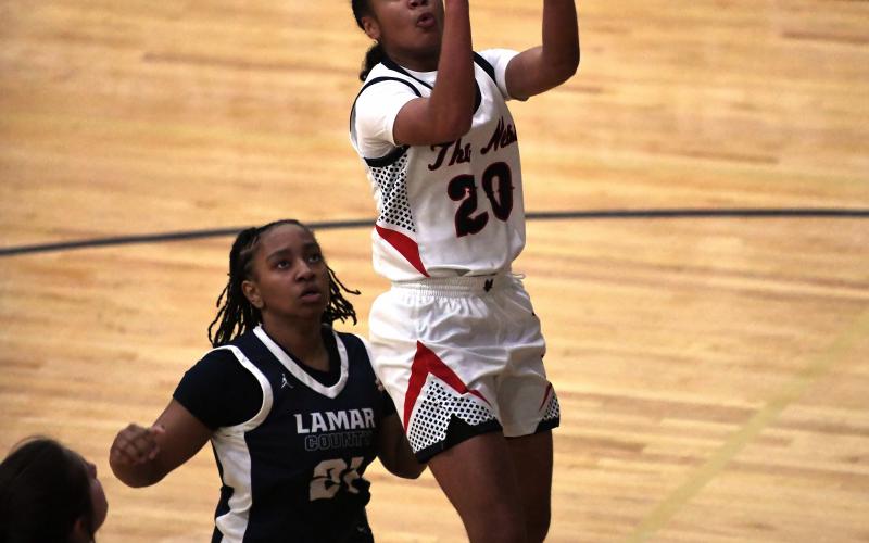 Putnam County freshman point guard Jaydah Baker (20) goes up for a layup over a Lamar County defender in a 70-56 win over the Lady Trojans on Jan. 28. Baker led the Lady War Eagles with 24 points in the win. IAN TOCHER/Staff