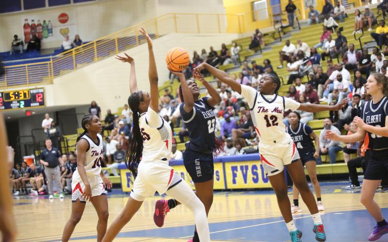Elbert County’s Zy Belcher (23) drives to the basket, contending with Putnam County’s De’Nadia Dunn (25) and Eriyana Little (12) in the paint. Courtesy of BO UNDERWOOD/Elberton Star