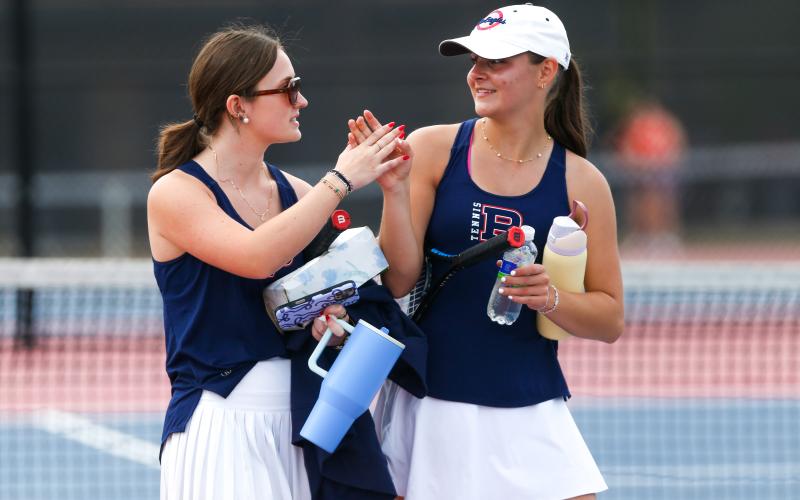 Putnam County’s No. 1 singles team of Addie Grace Usry (left) and Joelle Lukens (right) high-five after winning a point for the Lady War Eagles against Social Circle on Monday. LANCE McCURLEY/Staff
