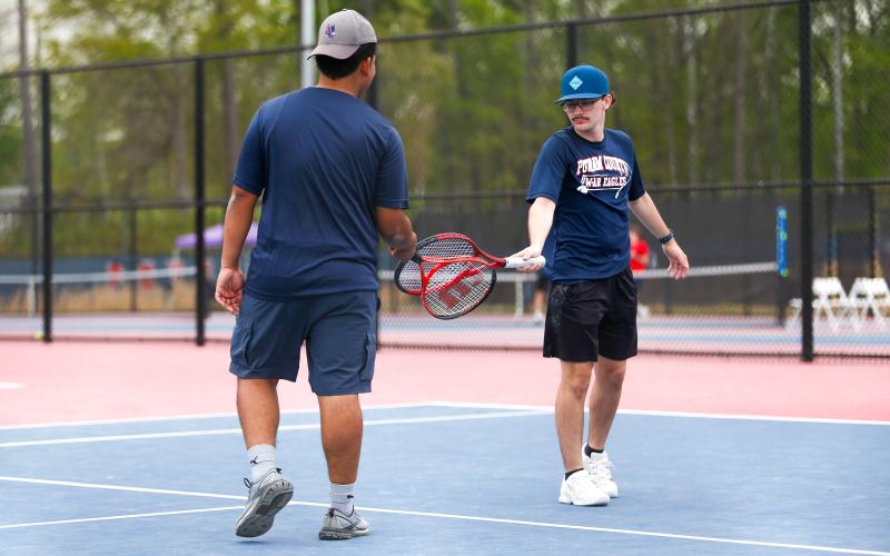 The No. 2 doubles team of Juan Patino (left) and Andrew Guillebeau (right) tap rackets while celebrating a point against Lamar County on Monday. LANCE McCURLEY/Staff