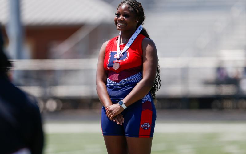Putnam County sophomore Jaslyn Foster smiles after receiving her medal for a third-place finish in the shot put event. LANCE McCURLEY/Staff