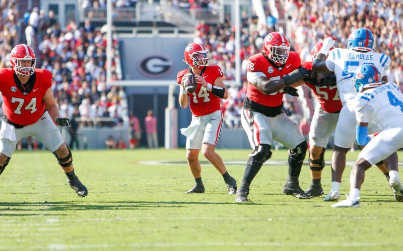Georgia quarterback Gunner Stockton (14) drops back to pass from the pocket during a game against Ole Miss last season. LANCE McCURLEY/Staff
