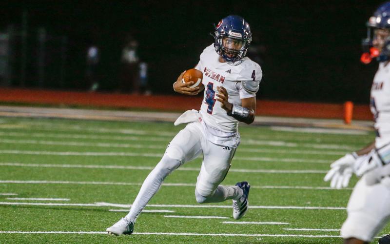 Putnam County junior quarterback Caleb Reeves (4) scrambles out of the pocket. LANCE MCCURLEY/Staff