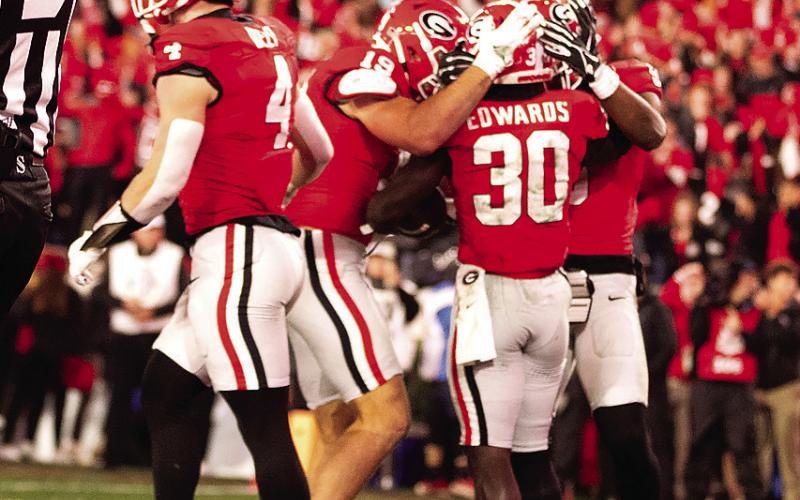 Running back Daijun Edwards (30) is congratulated by teammates after one of his rushing touchdowns. H e had two on the night. ZAK ROBINSON PHOTOGRAPHY/Contributed