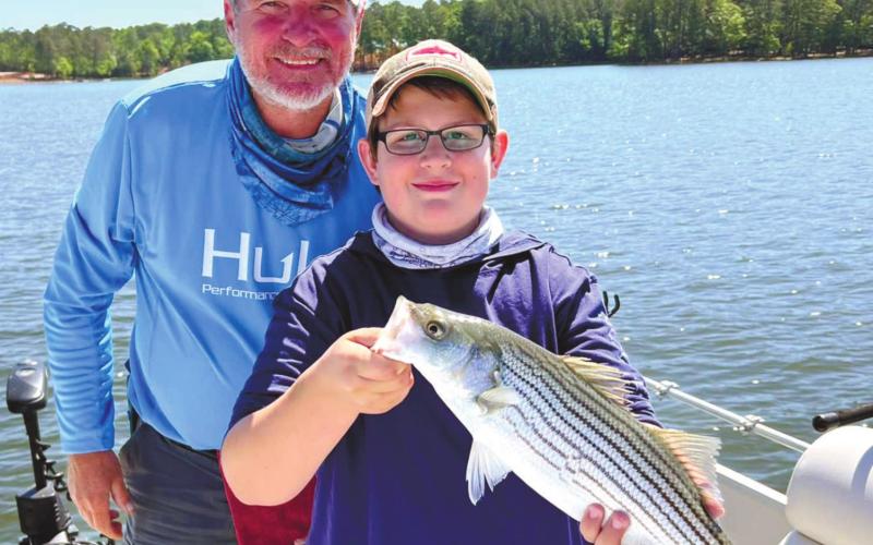 Kevin Harris and Beau with a striper. CONTRIBUTED