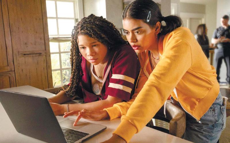 Jude, played by Storm Reid, (left) looks at Kevin’s social media with her best friend Veena, played by Megan Suri. TEMMA HANKIN/Sony Pictures