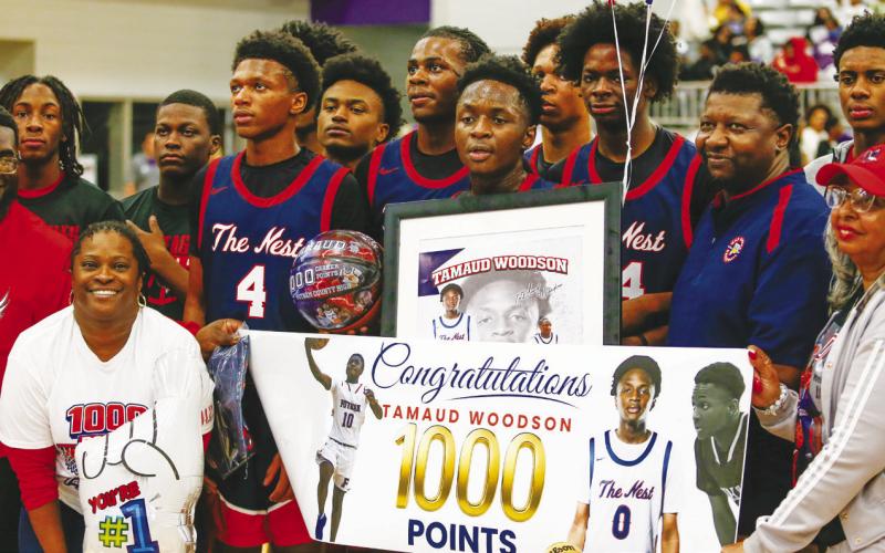 Putnam County senior Tamaud Woodson (center) celebrates with teammates and coaches during halftime of the Elite Eight game against Fitzgerald after reaching his 1,000th career point. LANCE MCCURLEY/Staff