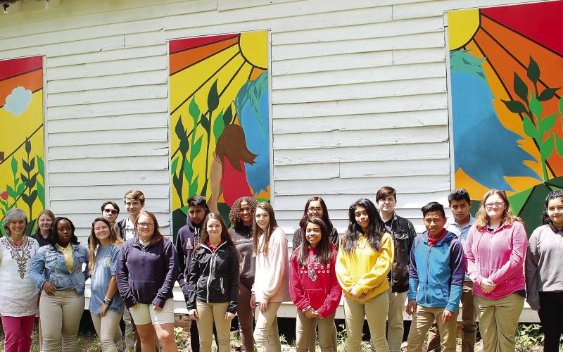 In 2019, Putnam County High School students pose with the new artwork they created to cover broken windows at Wards Chapel Church. FILE PHOTO