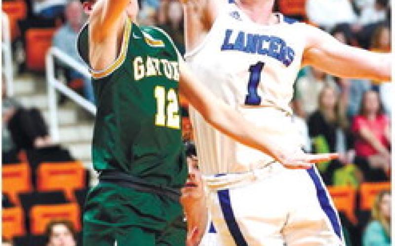 Gators’ leading scorer Matt Allen (12) goes up for a layup over CFCA’s Jeb Walls (1). DR. BOB BETZEL/Contributed