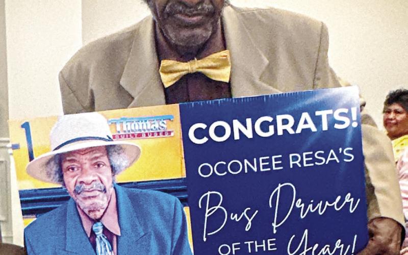 Willie Reid holds up the sign he received to honor his 56 years of service. CONTRIBTUED