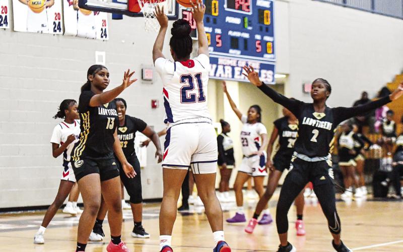 War Eagles’ senior Kamyra Aikens (21) shots a 3-pointer over Greene County defenders in a win on Dec. 8. CHARLES JORDAN/Staff