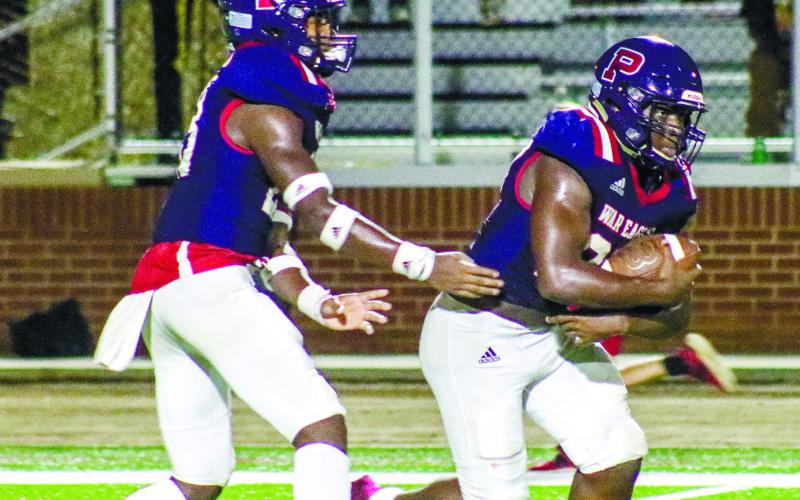 Peters (right) takes a handoff from wide receiver Jalon Kilgore out of the wildcat formation in a home game against Josey last season. LANCE McCURLEY/Staff