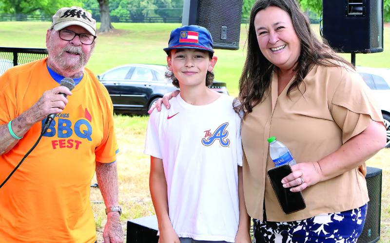 Announcer and volunteer with Pete Nance Boys &amp;amp; Girls Club, Jim Borland with 50/50 raffle winners of $500 were Grayson and mom Loren Sims. LEIGH LOFGREN/Staff