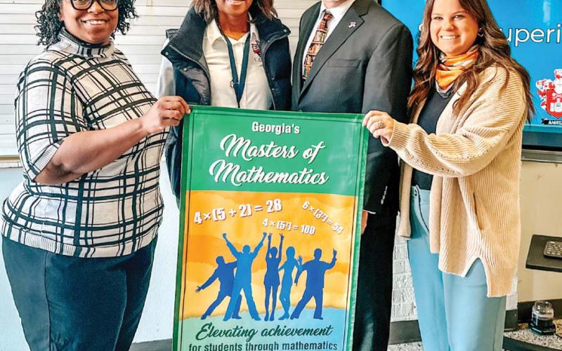 Putnam County Middle School eighth grade math teacher Crystal Watkins, Principal Monica Macklin, State Superintendent Richard Woods, and eighth grade math teacher Keeli Sanders show off the awarded banner. CONTRIBUTED