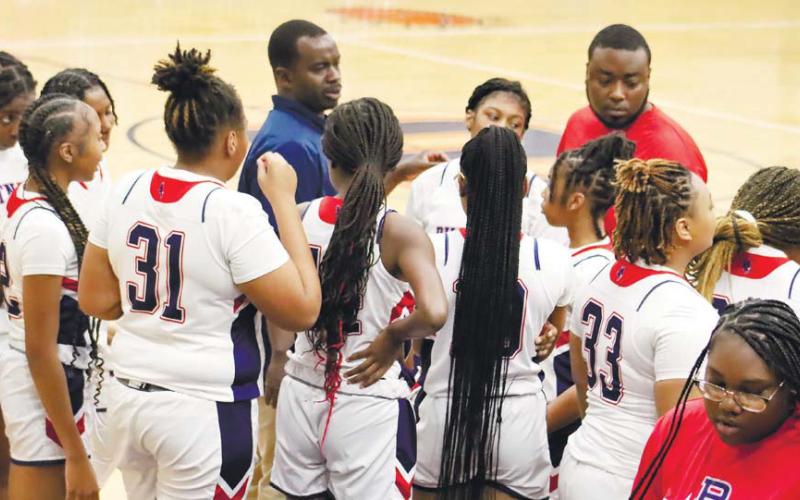 During a timeout, PCHS head coach Derrick Arrington (left) and assistant coach David Levester encourage the Lady Eagles to regroup.