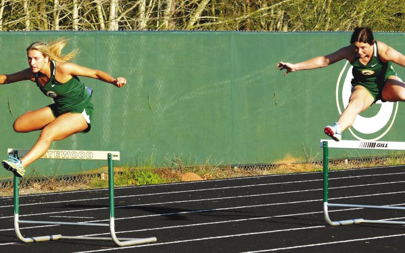 Seniors Anna Williamson (left) and Madison Hevesy compete for Gatewood in the girls’ 300-meter hurdles, with Hevesy finishing second while Williamson placed third. IAN TOCHER/Staff