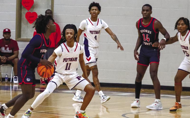 Messiah Walker (11) at the top of the key defending a Toombs County player in the first round of the 2022-23 Class AA state playoffs. LANCE McCURLEY/Staff