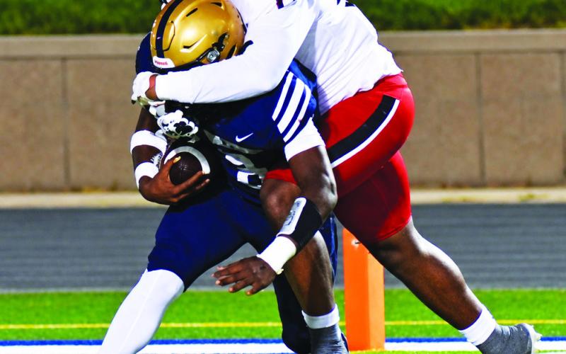 Brandon Jackson smothers a Jefferson Co. runner well behind the line of scrimmage last Friday night against the Warriors. BRANDON PARK/Staff