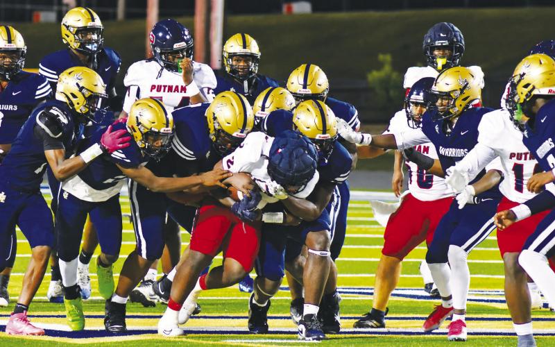 It took half the Warrior’s defense to bring down Putnam running back Kumari Thomas, who totaled 256 rushing yards and 4 TDs last Friday night. BRANDON PARK/Staff