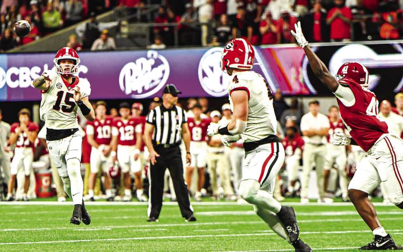 Georgia quarterback Carson Beck (15) hits tight end Oscar Delp (4) on the run. CHARLES JORDAN/Staff