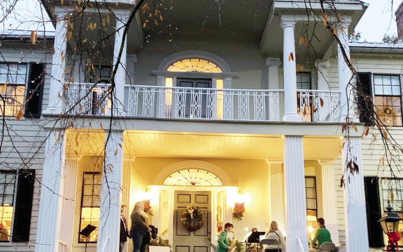 The Baldwin High School sax ensemble performed on the front porch of the historic home welcoming people in. Two attendees stopped to watch and hum along to the tunes of Christmas songs. BAILEY MCCULLY/Staff