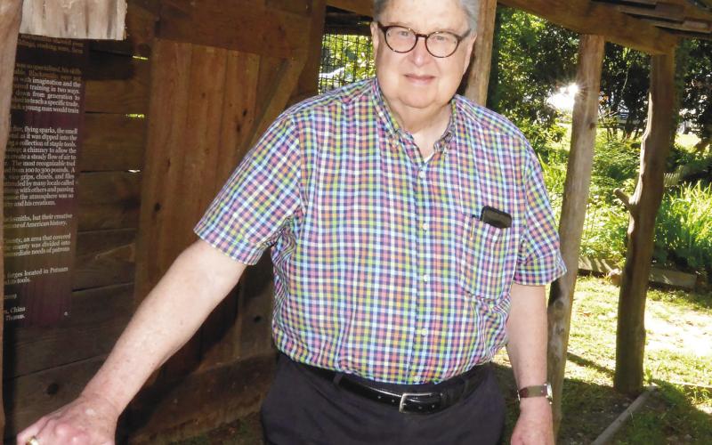 Local historian and Uncle Remus Museum board member Jim Marshall stands alongside the replica blacksmith shop that was built as an Eagle Scout project. IAN TOCHER/Staff