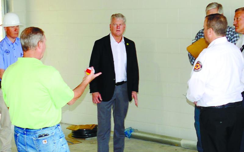 District 10 Congressman Mike Collins (center) speaks with Putnam County Manager Paul Van Haute (in green), with (l-r) County Clerk Lynn Butterworth, Eatonton Councilmember Janie Reid and Eatonton Mayor John Reid among local dignitaries touring the county’s new fire station under construction behind the county offices off the Hwy. 441 bypass. IAN TOCHER/Staff