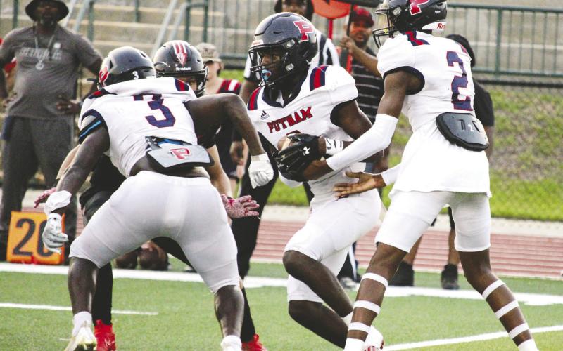 Putnam County quarterback Jamarion Robertson (2) hands the ball off to Mark Little (6). TREY NORRIS/Staff