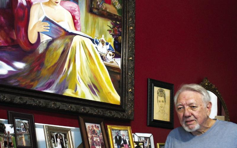 Dennis McClain poses in his bedroom with a portrait of his wife, Dottie, that he painted several years ago. (IAN TOCHER/Staff)