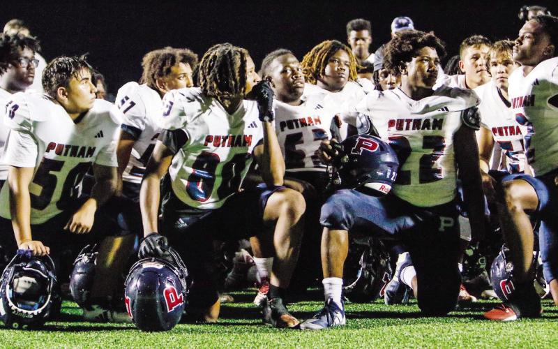 Putnam County players listen to head coach Joel Harvin’s postgame speech this past Friday after losing to Greene County. (LANCE MCCURLEY/Staff)