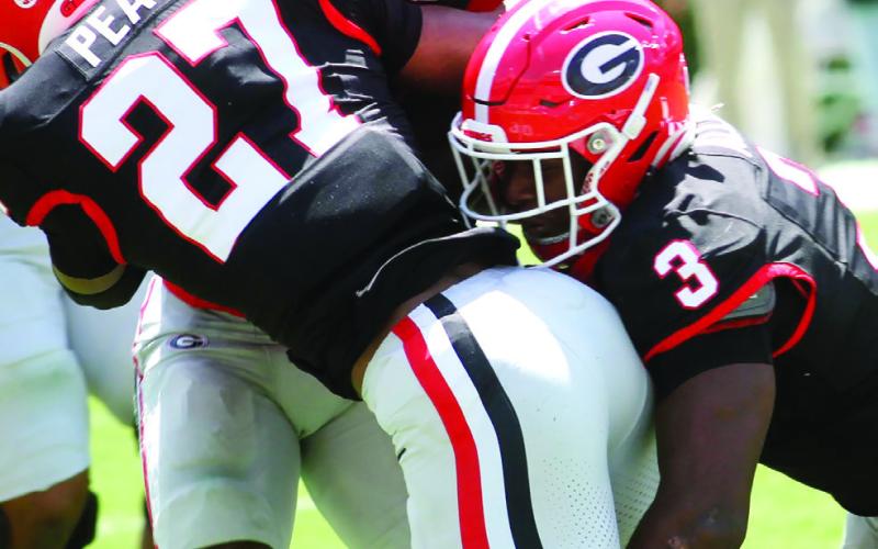 Georgia defender Chris Peal (27) and linebacker CJ Allen (3) bring down a ball carrier. BRAD HARRISON/Staff