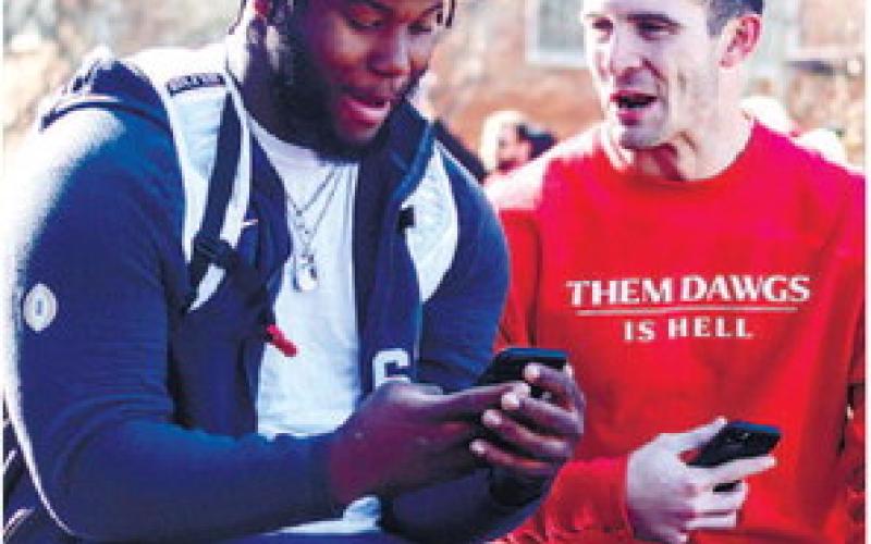 Georgia offensive lineman Sedrick Van Pran (left) and quarterback Stetson Bennett (right) share a laugh during the parade. LANCE MCCURLEY/Staff