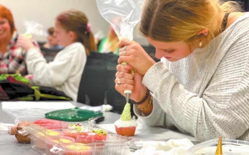 Student decorating a cupcake during the Holiday Cupcake Decorating course taught by six-time Food Network Champion, Reva Alexander Hawk. CONTRIBUTED
