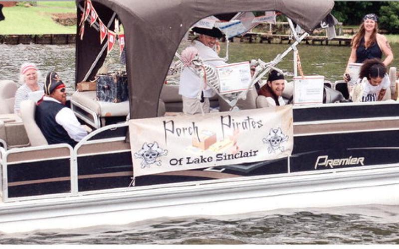 Postal worker Mickey Hearn (far left) and her daughter Denisia (right) had the inspiration for “Porch Pirates of Lake Sinclair” shortly after last year’s Pirate Parade on Lake Sinclair and it paid off with a Best Decorated award this year.