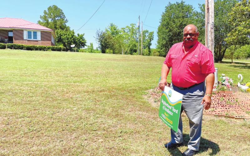 Eatonton Mayor John Reid places sign in Ward 1 winners’ Charles and Martha Parham’s yard. CONTRIBUTED