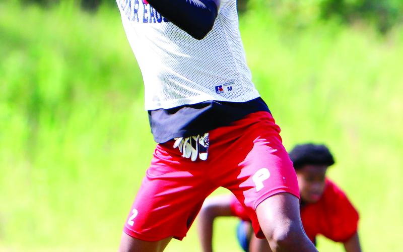 Putnam County quarterback Jamarion Robertson drops back to pass during a practice in June. LANCE McCURLEY/Staff