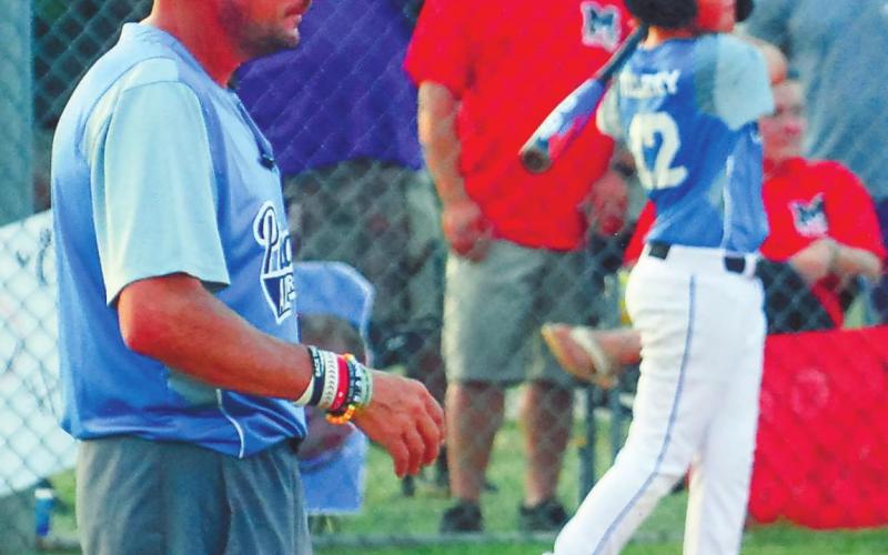 Putnam County head coach Grayson Huskins watches his team warm up, including Ethan Tillery (12).